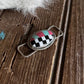 Checkered twilly slide on a wooden surface with horse hair visible
