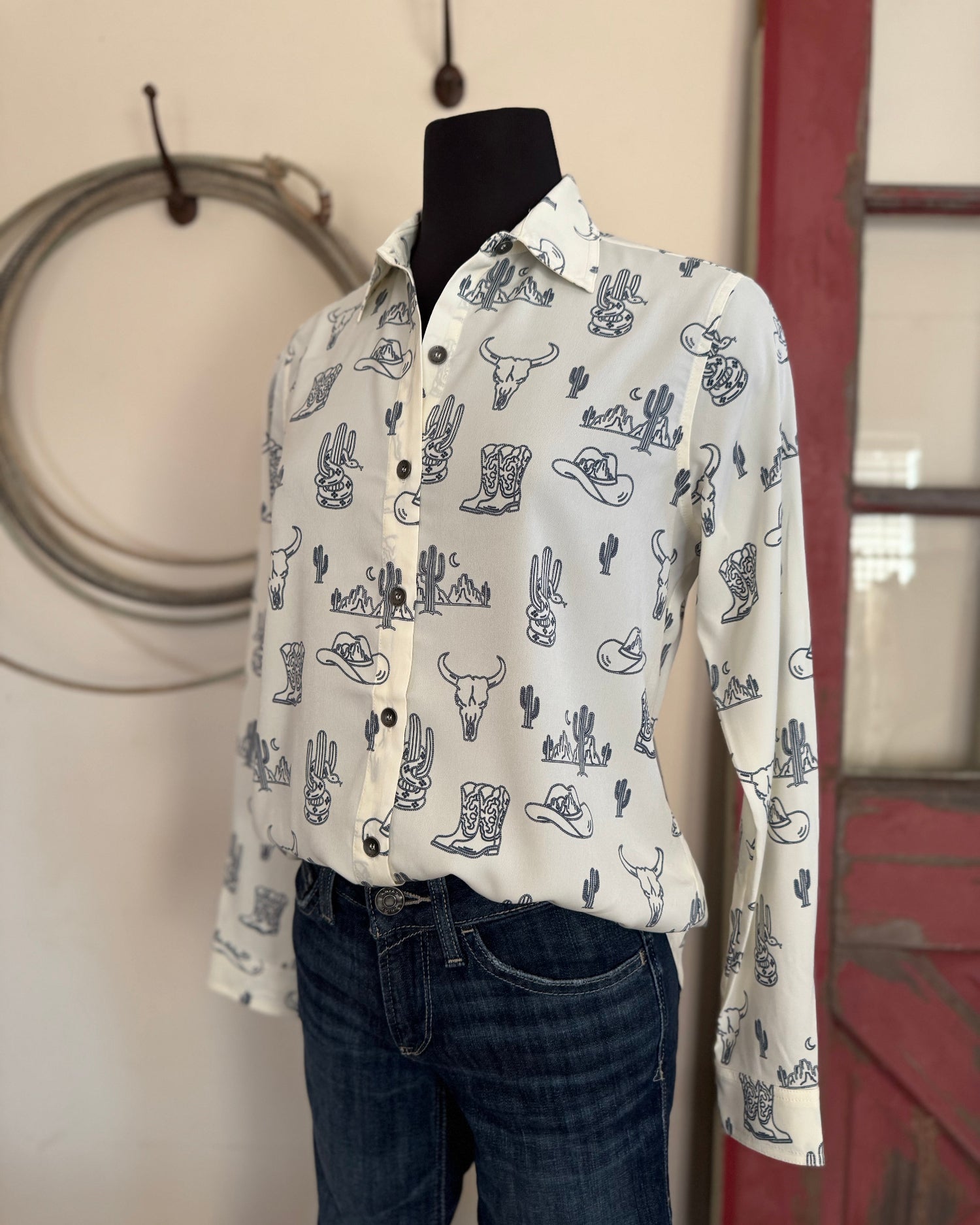 Mannequin wearing a white shirt with blue patterns in a room with a red door and beige wall.