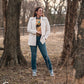 Model standing in trees, dressed in a stylish modern western outfit.