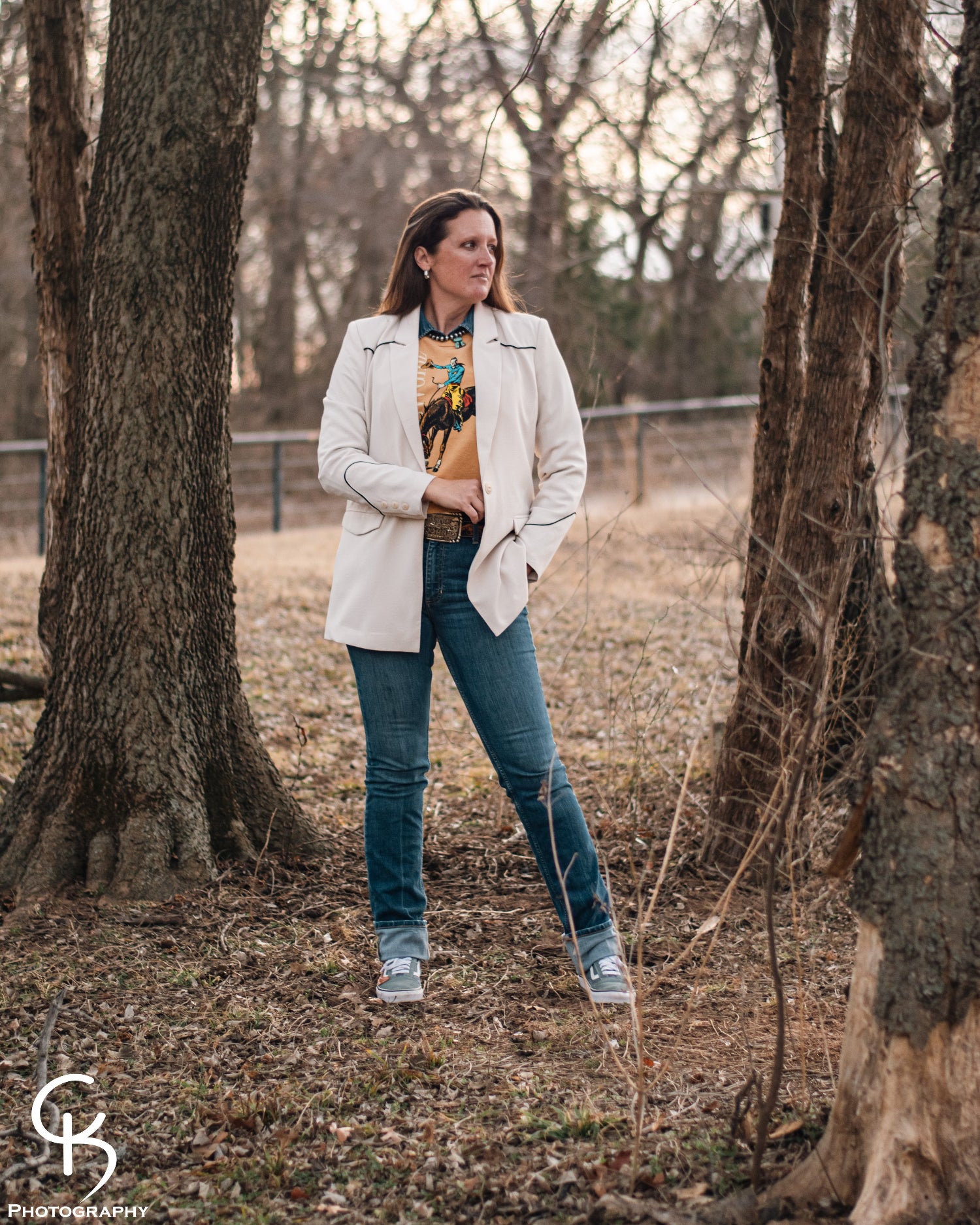 Model standing in trees, dressed in a stylish modern western outfit.