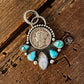 Pendant with turquoise stones on a wooden surface
