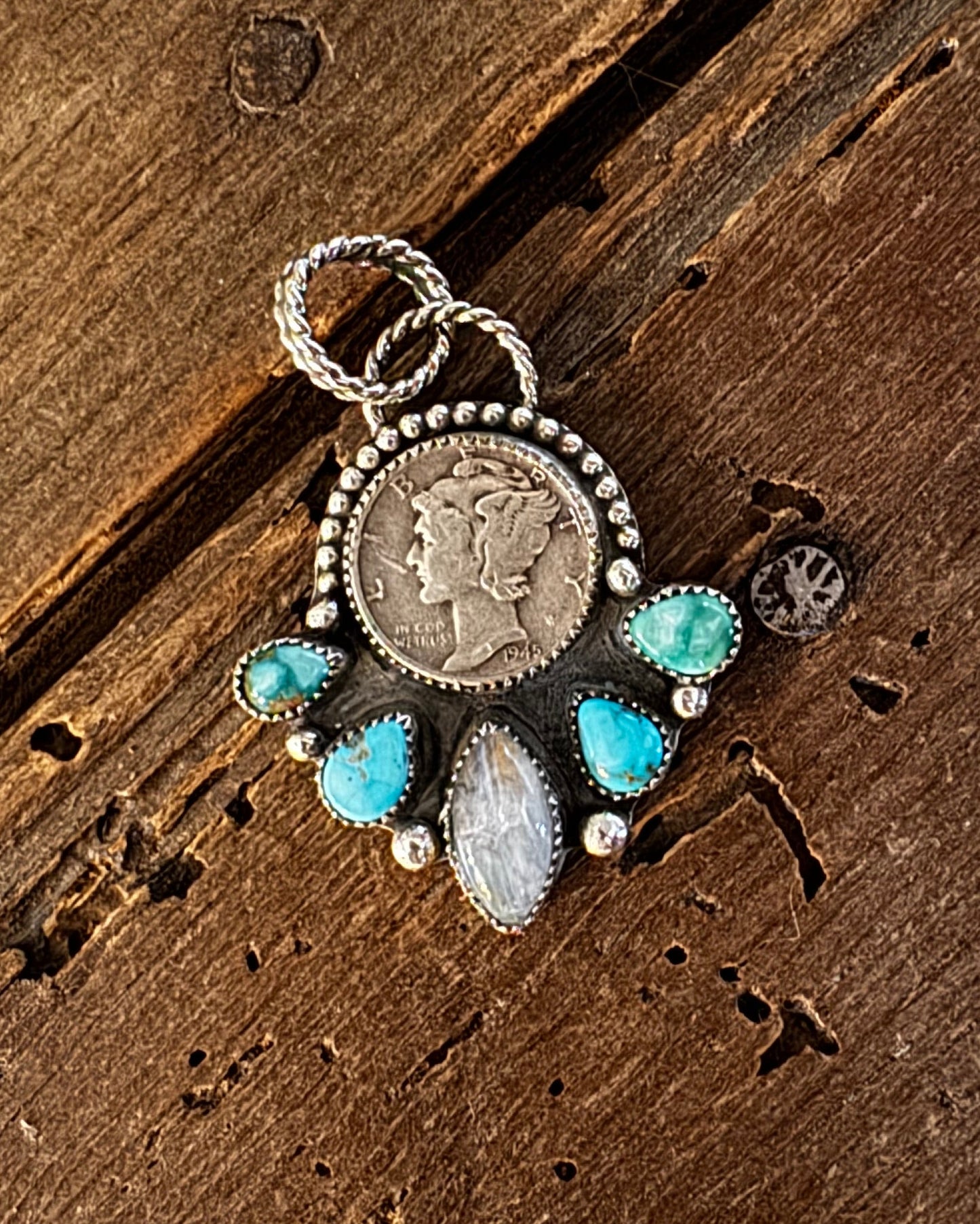 Pendant with turquoise stones on a wooden surface