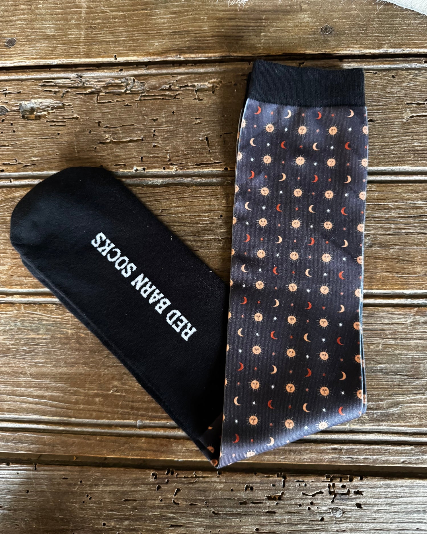 Black sock with 'Red Bar N' logo and patterned tie on a wooden surface