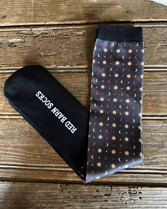 Black sock with 'Red Bar N' logo and patterned tie on a wooden surface
