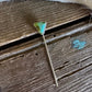 Necklace with a green pendant on a wooden surface