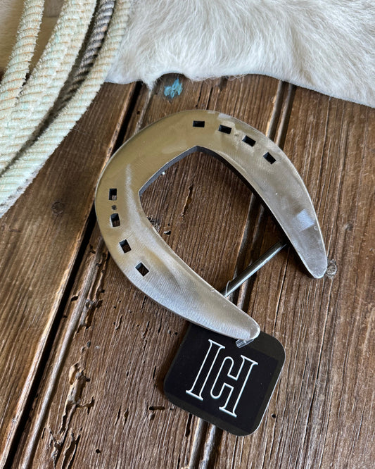 Horseshoe with a black tag on a wooden surface