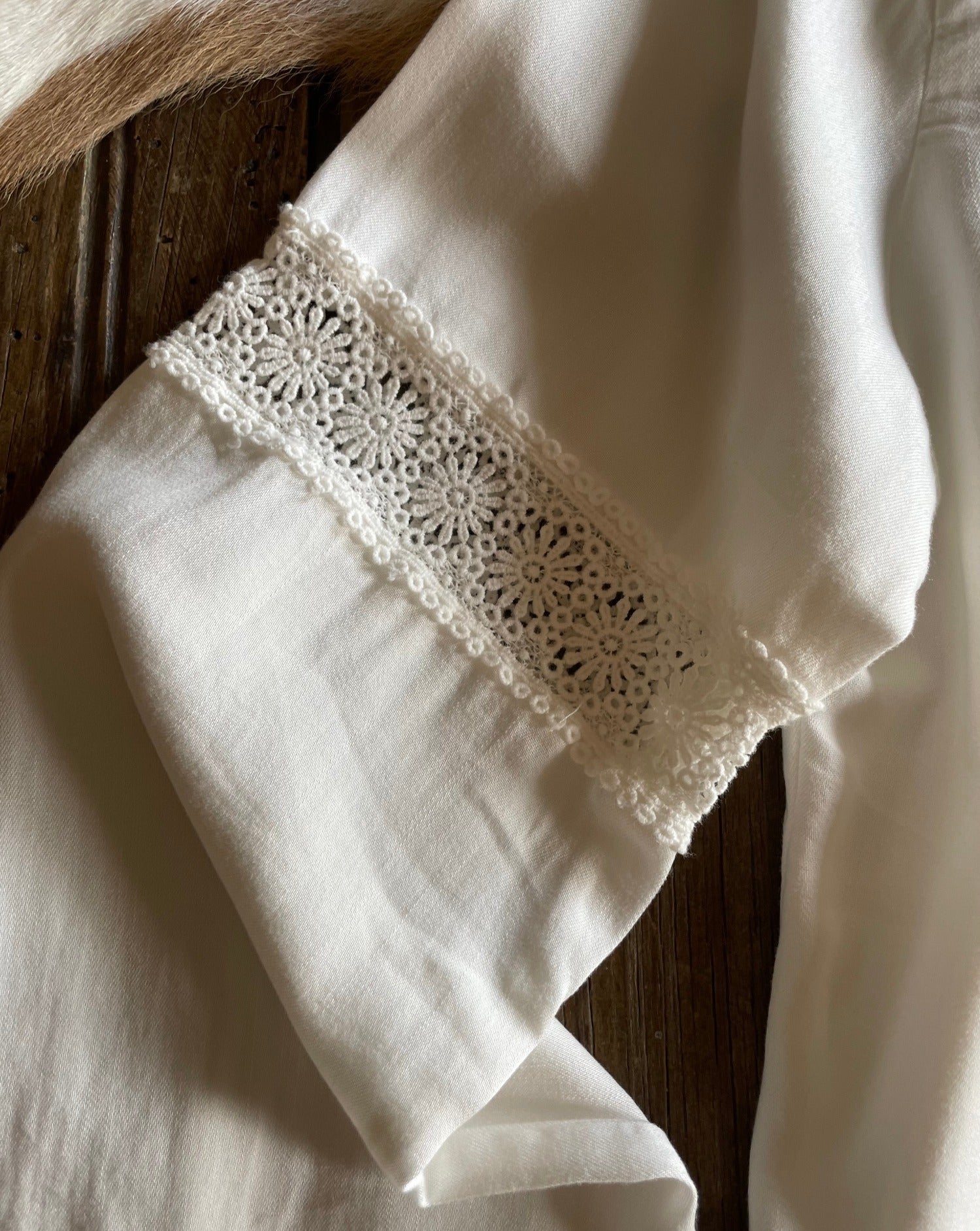 Close up of lace sleeve detail on off white blouse