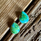 Turquoise teardrop earrings on a wooden surface