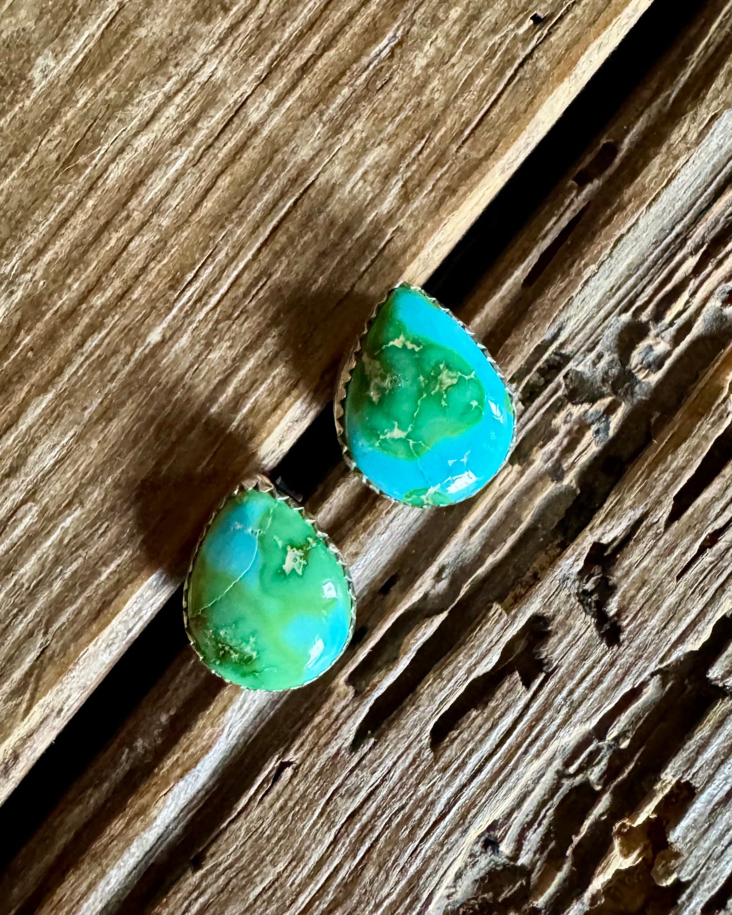 Turquoise teardrop earrings on a wooden surface