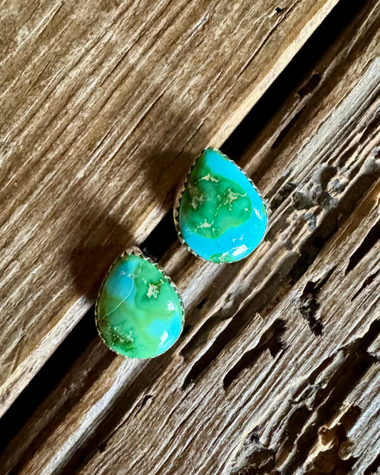 Turquoise teardrop earrings on a wooden surface