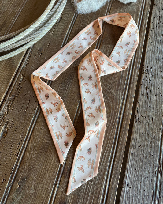 Twilly scarf with cowboys on a wooden background with a rope and cowhide