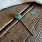 Turquoise stone earring on a wooden surface
