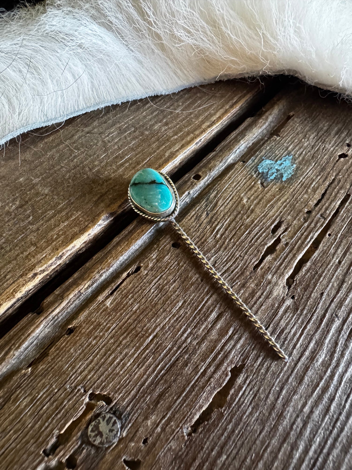 Turquoise stone earring on a wooden surface