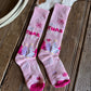 Pink socks with floral patterns on a wooden floor
