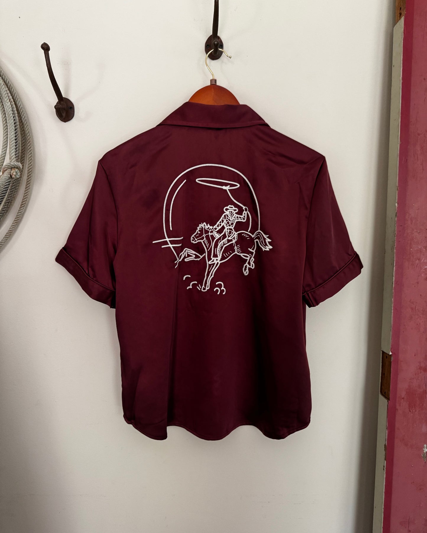 Maroon sweatshirt with a white graphic on a white surface