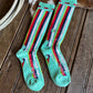 Pair of colorful striped socks on a wooden floor.