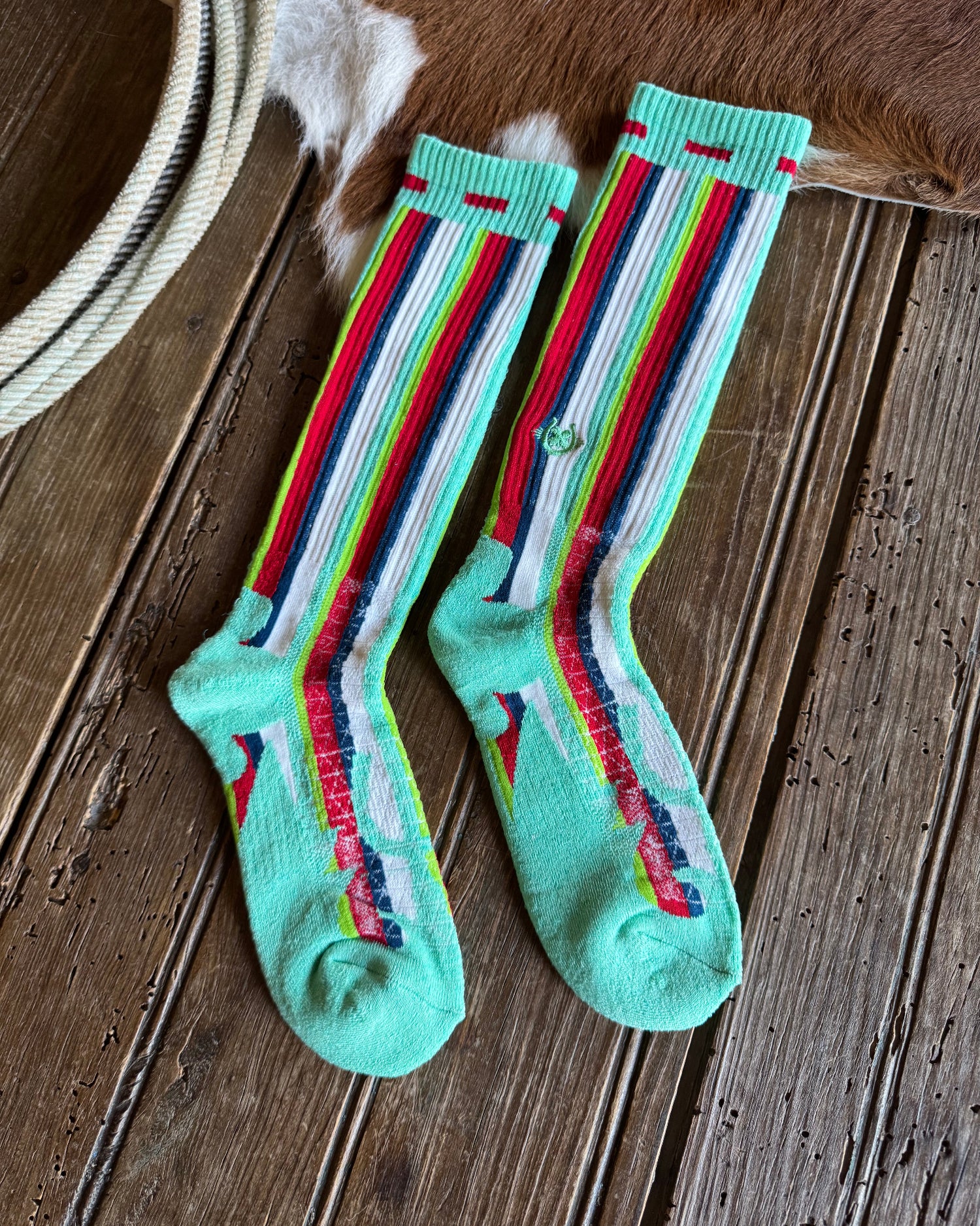 Pair of colorful striped socks on a wooden floor.