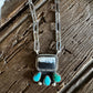 Silver necklace with turquoise stones on a wooden surface