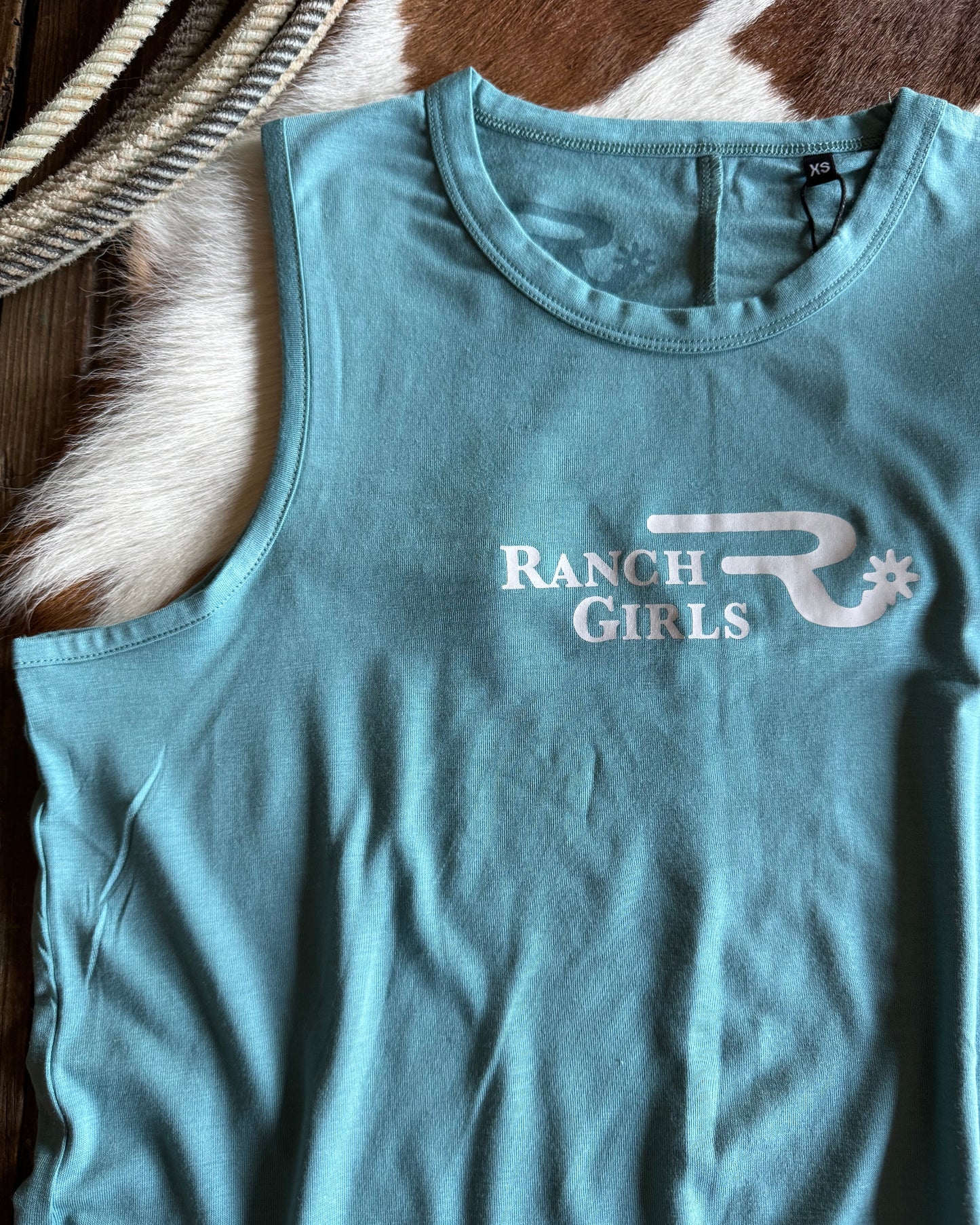 Blue tank top with 'Ranch Girls' text on a textured surface