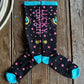Pair of socks with 'Lucky Cowgirl' text on a wooden surface
