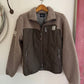 Two-tone jacket with brown fleece collar and black body on a wooden hanger against a white wall.