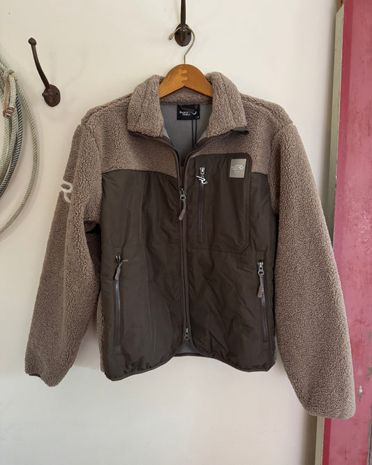 Two-tone jacket with brown fleece collar and black body on a wooden hanger against a white wall.