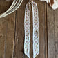 ribbon scarve with intricate patterns on a wooden surface.