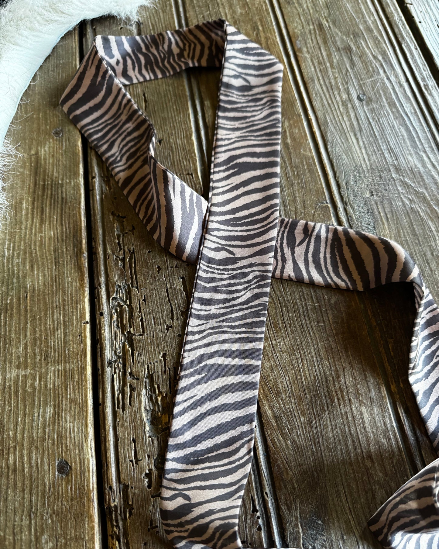 Zebra-striped scarf on a wooden surface