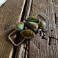 Jewelry with green stones on a wooden surface