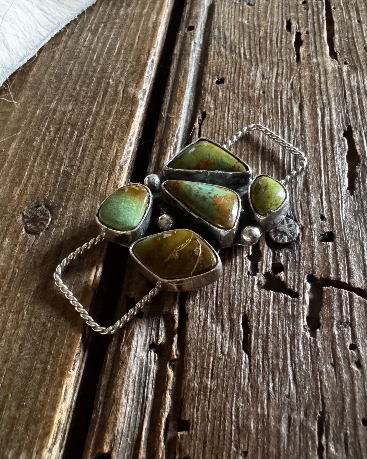 Jewelry with green stones on a wooden surface