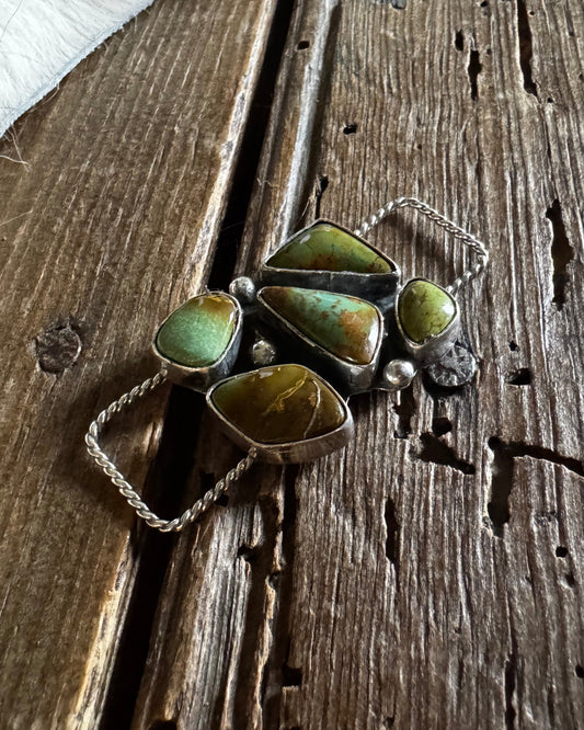 Jewelry with green stones on a wooden surface