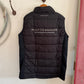 Black puffer vest with text on a white wall
