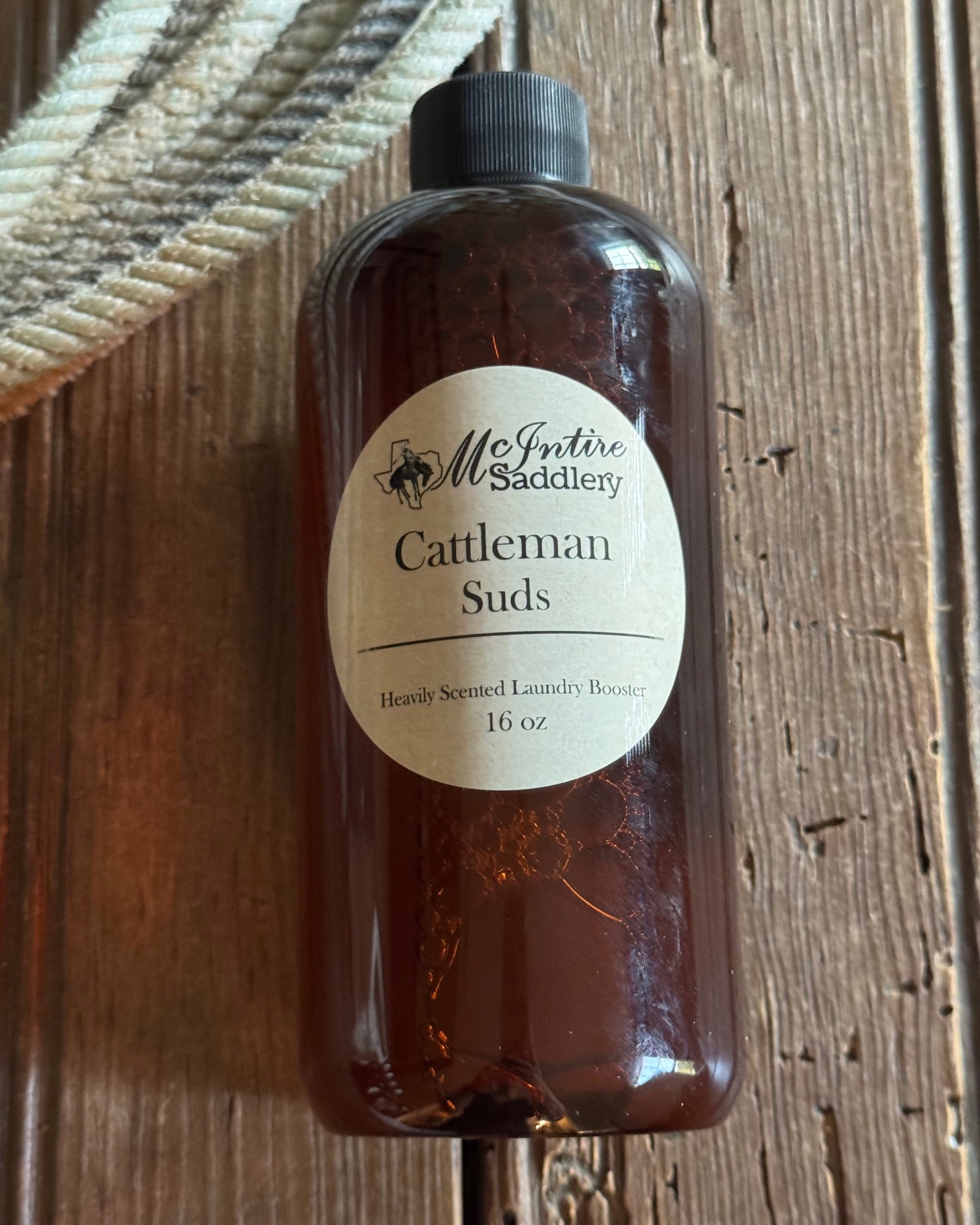 Bottle of saddle soap with a label on a wooden surface