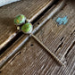 Pair of turquoise stone earrings on a wooden surface