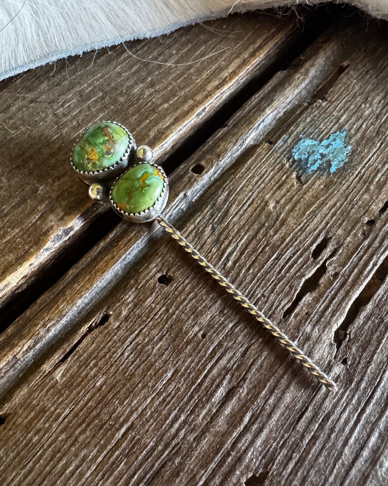 Pair of turquoise stone earrings on a wooden surface