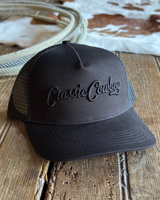 Black cap with 'Classic Cowboy' logo on a wooden surface