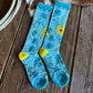 Pair of blue socks with floral patterns on a wooden floor.