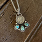 Liberty dime pendant with turquoise stones on a wooden background