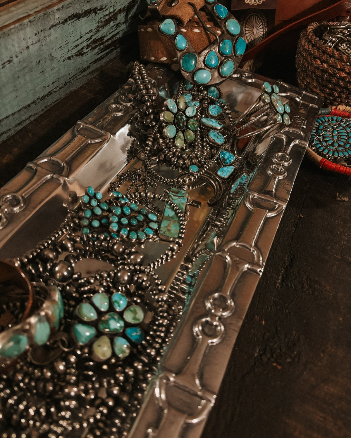 Close-up of silver and turquoise jewelry on a dark surface