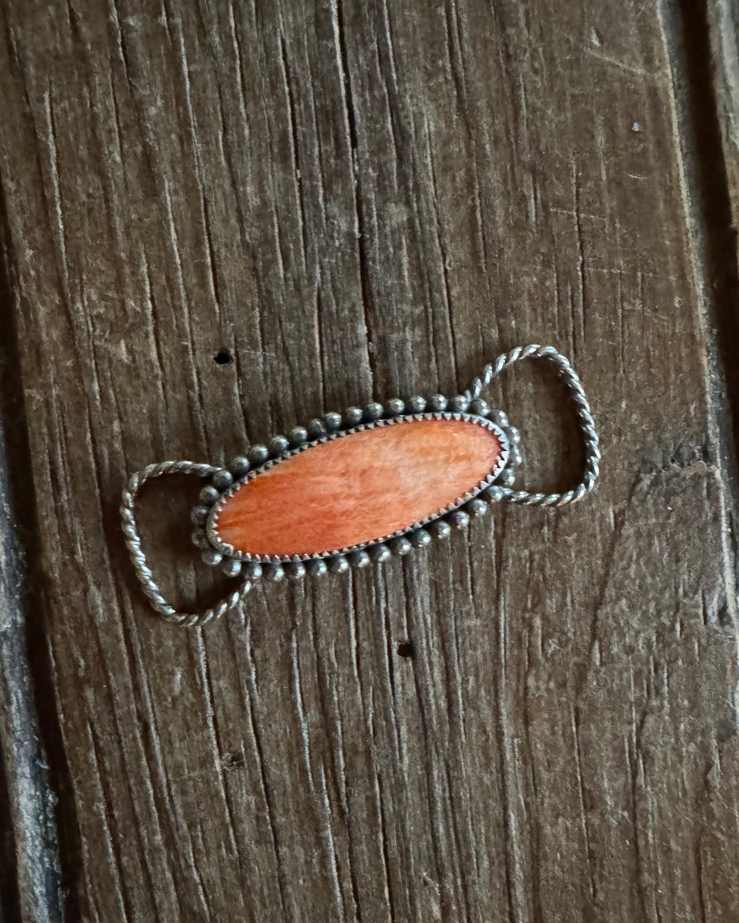 Twilly slide with a wooden pendant on a wooden surface