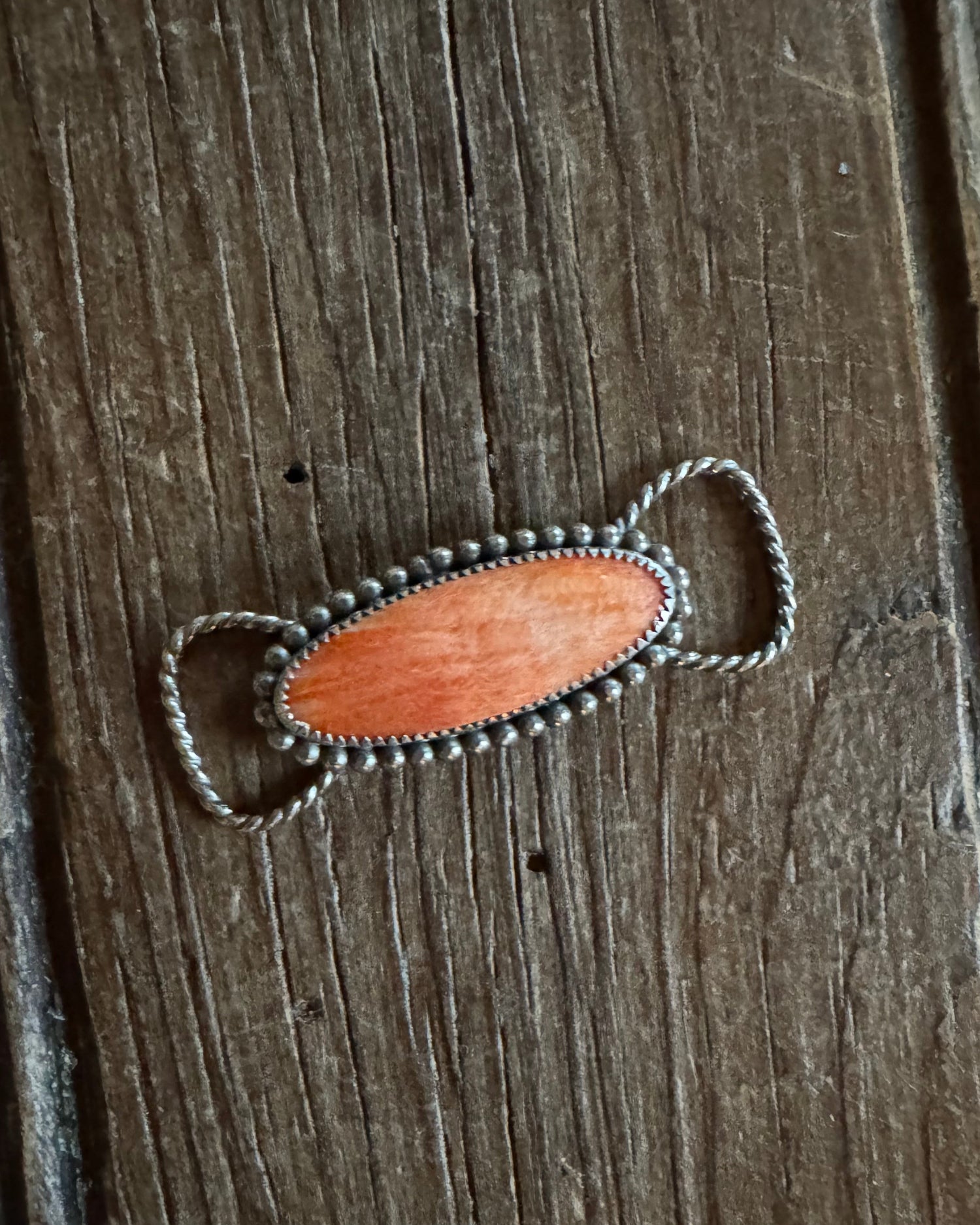 Twilly slide with a wooden pendant on a wooden surface