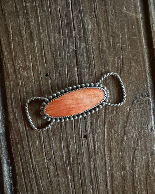 Twilly slide with a wooden pendant on a wooden surface