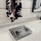 Decorative silver tray on a marble surface with a patterned towel in the background.