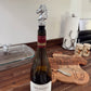 Wine bottle with a horse-shaped stopper on a wooden surface