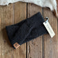 Dark gray knit headband with Ariat tag on a wooden surface