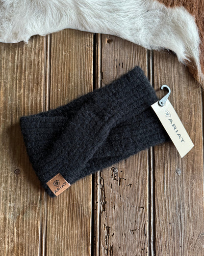 Dark gray knit headband with Ariat tag on a wooden surface
