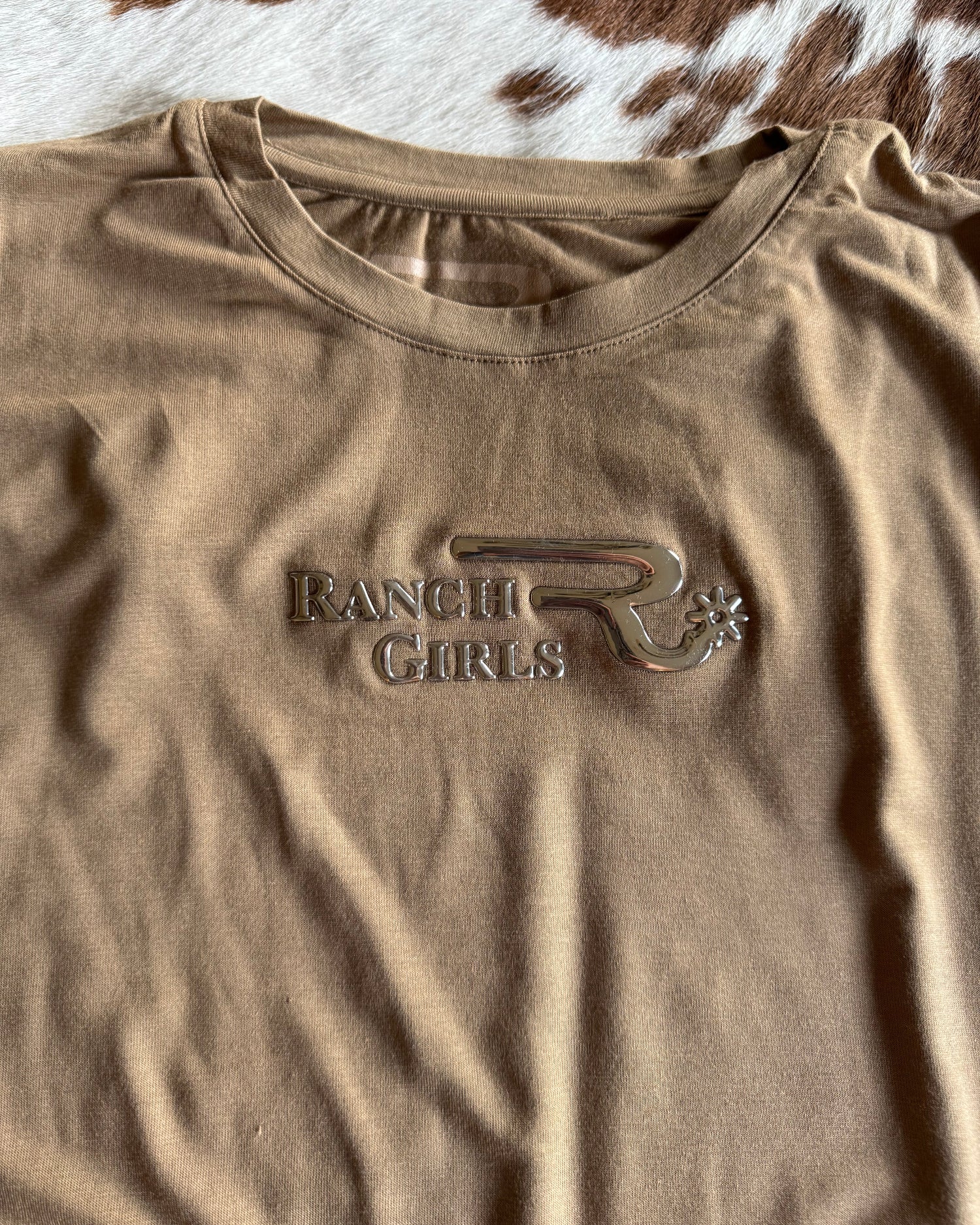 Brown t-shirt with a logo on a cowhide background
