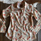 Floral-patterned shirt on a wooden surface with cowhide rug