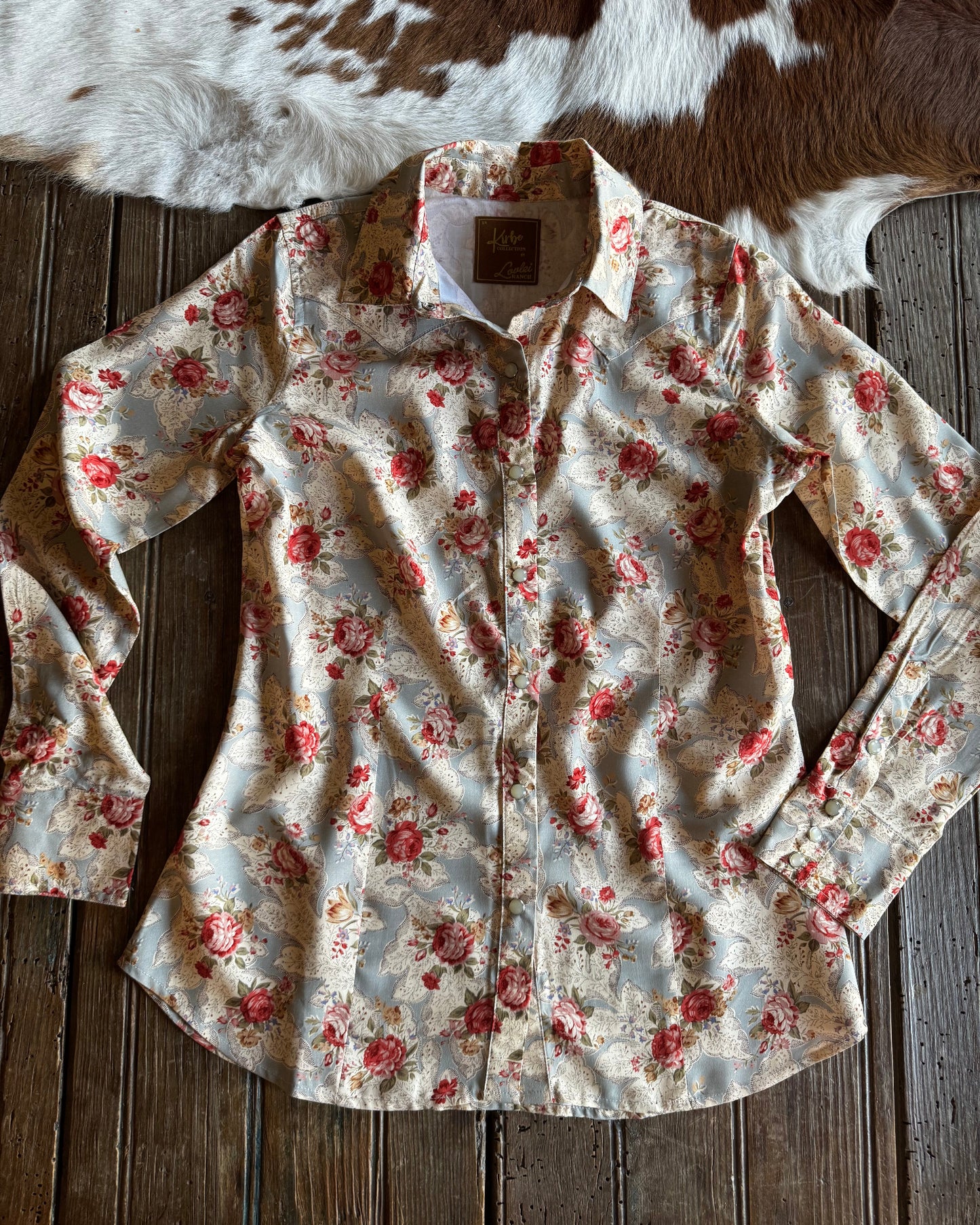 Floral-patterned shirt on a wooden surface with cowhide rug