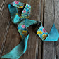 Twilly Scarf with flowers on a wooden surface